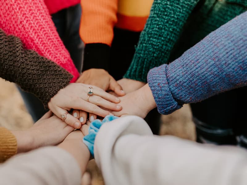 A group of diverse hands together in a circle